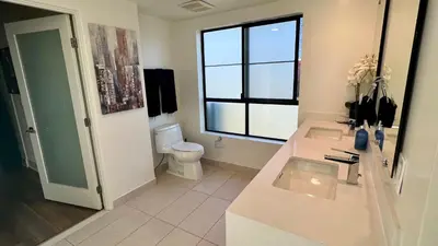 a bathroom with a sink and a toilet and a window at Century City Cozy 3 Bedroom Apartment with Parking 302,303 in Los Angeles