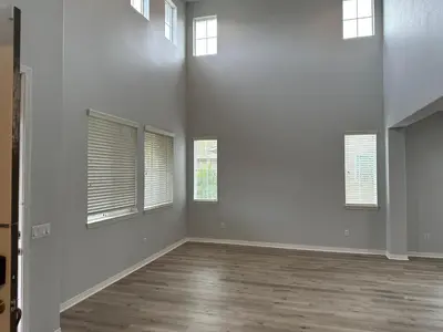 an empty living room with white walls and windows at ALE Displaced, Relocation, Insurance, Fire, Flood in Corona