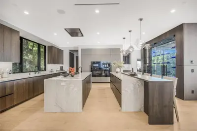 a large kitchen with marble counter tops and wooden cabinets at Levitt Lane in Los Angeles
