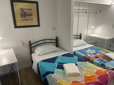 a bedroom with two beds with a colorful blanket at Walking Distance Disney in Anaheim in Anaheim