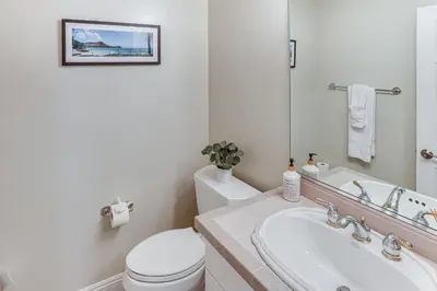 a bathroom with a toilet and a sink and a mirror at Lake Arrowhead Home Mountain View, Walk to Water! in Lake Arrowhead