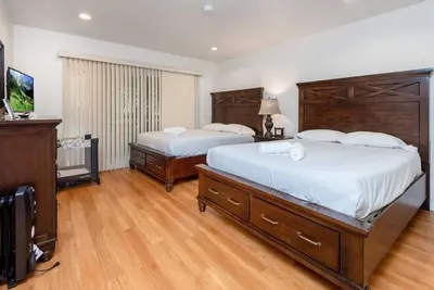a bedroom with two beds and a flat screen tv at Central LA Bliss: 5 BR Home, BBQ, Perfect Location in Los Angeles
