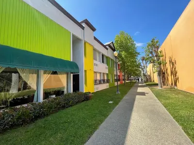 a walkway between two buildings with green and yellow at Hotel Pacific Garden in Gardena
