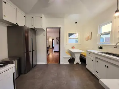 a kitchen with white cabinets and a sink and a refrigerator at Glamorous Getaway: Exclusive 1BR LA Hotspots in Los Angeles