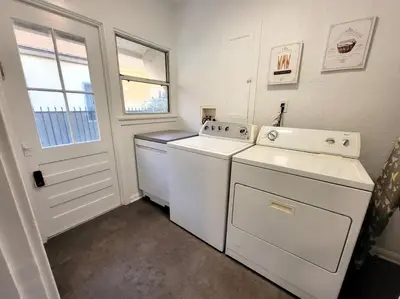 a laundry room with white appliances and a window at Glamorous Getaway: Exclusive 1BR LA Hotspots in Los Angeles