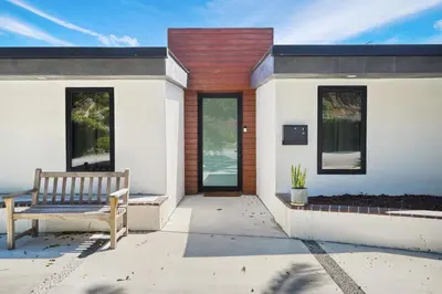 a bench sitting on a patio in front of a house at Stunning Modern 5BR Family Mansion, Panoramic views of Penmar Golf, Pet Friendly! in Los Angeles