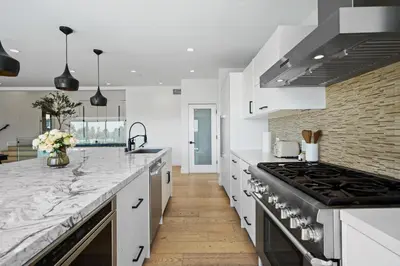 a kitchen with white counter tops and a stove at Stunning Modern 5BR Family Mansion, Panoramic views of Penmar Golf, Pet Friendly! in Los Angeles