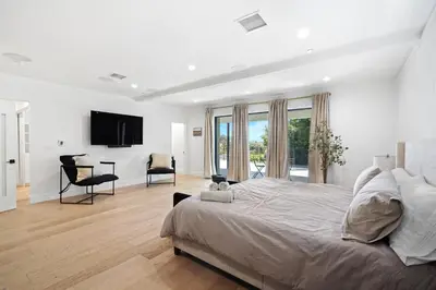 a white bedroom with a large bed and a desk at Stunning Modern 5BR Family Mansion, Panoramic views of Penmar Golf, Pet Friendly! in Los Angeles