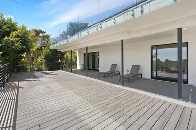 a wooden deck with two chairs on a house at Stunning Modern 5BR Family Mansion, Panoramic views of Penmar Golf, Pet Friendly! in Los Angeles
