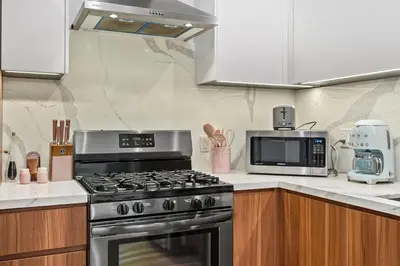 a kitchen with a stove and a microwave at Scandinavian 2BR, 2Bath Townhome, Pet & Kid Friendly, Free Parking, 10min to Venice Beach! in Los Angeles
