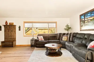 a living room with a leather couch and a table at Lakeside Paradise Escape in Big Bear Lake
