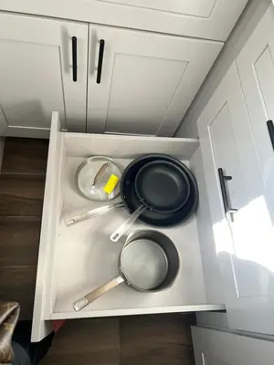 a white cabinet with pans and utensils in it at An Amazing comfortable home front middle unit 1q bed and other room with sofa in Los Angeles