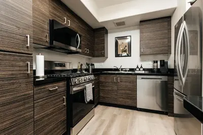 a kitchen with wooden cabinets and stainless steel appliances at Central Quality 2 BD Apartment in Los Angeles