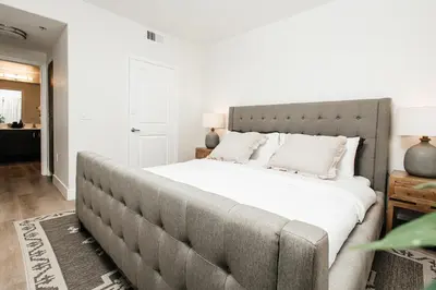 a bedroom with a large bed with white sheets at Central Quality 2 BD Apartment in Los Angeles