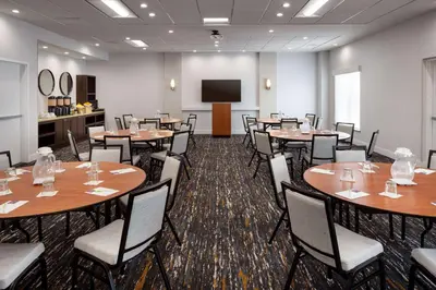 a conference room with tables and chairs and a screen at Hyatt Place at Anaheim Resort / Convention Center in Anaheim