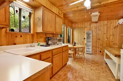 a kitchen with wooden cabinets and a sink and a table at Pine nest#2296 in Big Bear Lake