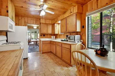 a kitchen with wooden cabinets and a table with chairs at Pine nest#2296 in Big Bear Lake