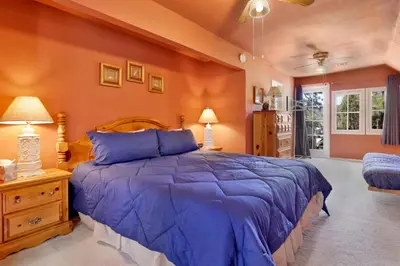 a bedroom with a large blue bed and orange walls at JUS' RESTIN #265 in Big Bear Lake