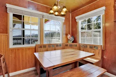a dining room with a wooden table and windows at FRANK'S OLD BEAR #149 in Big Bear Lake