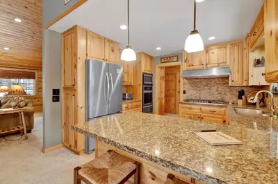 a kitchen with wooden cabinets and a stainless steel refrigerator at All about fun #1149 in Big Bear Lake
