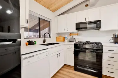 a kitchen with white cabinets and a black stove top oven at Chairlift lodge#2354 in Big Bear Lake