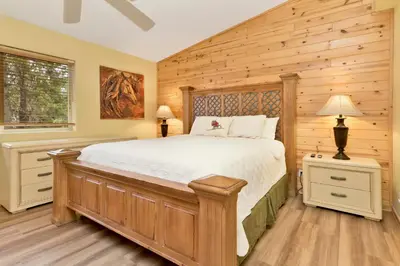 a bedroom with a bed and a wooden wall at CAN'T BEAR TO LEAVE #1156 in Big Bear Lake