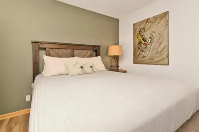 a bedroom with a white bed and a painting on the wall at CAN'T BEAR TO LEAVE #1156 in Big Bear Lake