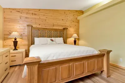 a bedroom with a bed and wooden walls at CAN'T BEAR TO LEAVE #1156 in Big Bear Lake