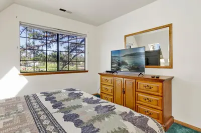 a bedroom with a bed and a dresser and a mirror at Breezy one #112 in Big Bear Lake