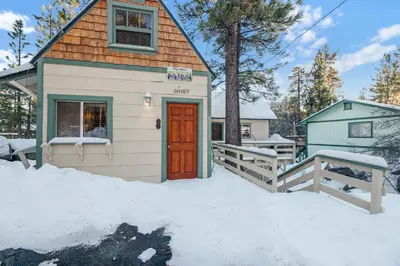 a tiny house with a red door in the snow at Fawnskin pines #2259 in Fawnskin