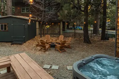 a backyard with a hot tub and a table and chairs at The lost compass #2165 in Big Bear Lake