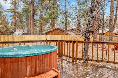 a hot tub on a deck with a fence at Timber pines chalet #2417 in Big Bear Lake