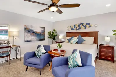 a bedroom with a bed and two blue chairs at Majestic sky retreat #2090 in Big Bear Lake