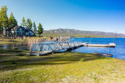 a dock on a lake with a house in the background at Lonepine#107 in Big Bear Lake