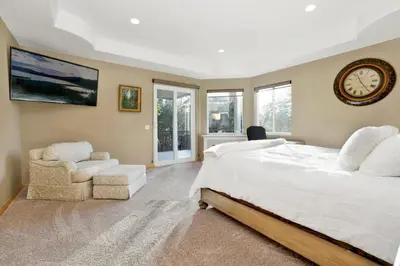 a bedroom with a large bed and a clock on the wall at Sunset ridge villa #2178 in Big Bear Lake