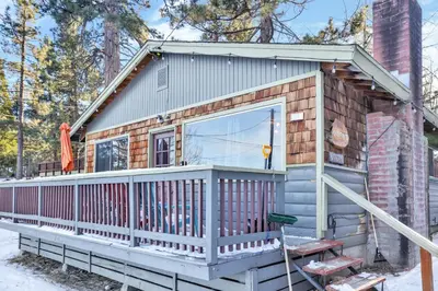 a tiny house with a porch and a large window at Lakefront #110 in Big Bear Lake