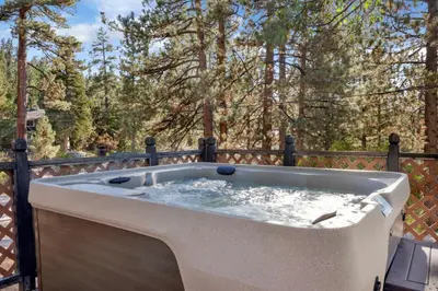a hot tub on a deck with trees in the background at Moulin rouge #2055 in Big Bear Lake