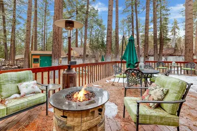 a fire pit on a deck with chairs and tables at Flitterbick lodge #2246 in Fawnskin