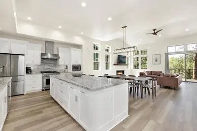 a kitchen with white cabinets and a dining room at The pines retreat #2336 in Big Bear Lake