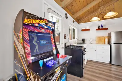 a kitchen with a refrigerator with a video game on it at Storyville #2294 in Big Bear Lake