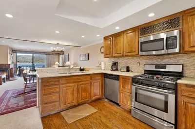 a kitchen with wooden cabinets and stainless steel appliances at Forest shores lake view condo #2250 in Big Bear Lake