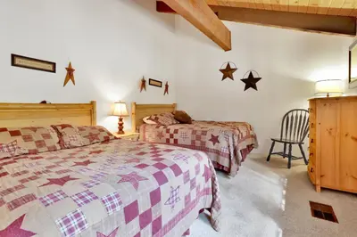 a bedroom with two beds and a chair at All season alpine retreat #1184 in Big Bear Lake