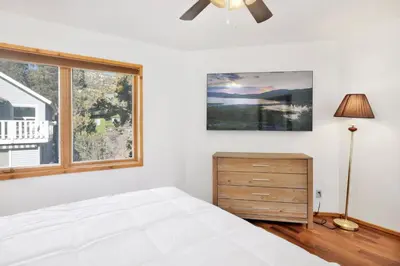 a white bedroom with a bed and a window at The octagon #2394 in Big Bear City