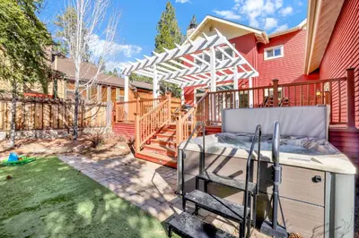 a backyard with a grill and a red house at The grand chalet #1989 in Big Bear Lake