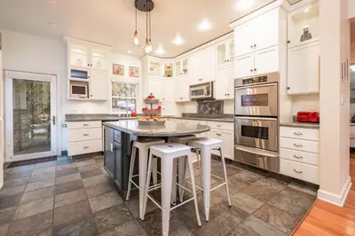 a kitchen with white cabinets and a island with stools at The grand chalet #1989 in Big Bear Lake