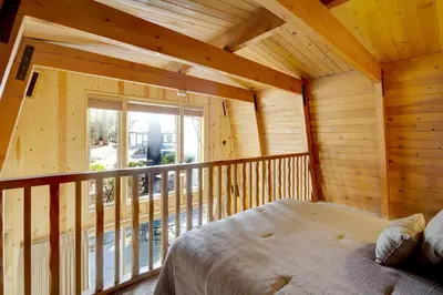 a bedroom in a log cabin with a bed on a balcony at Switzerland ski chalet #845 in Big Bear Lake