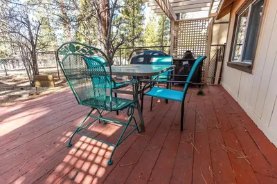 a patio with a table and chairs on a deck at Pines 23 #1438 in Big Bear Lake
