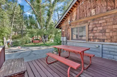 a red picnic table and a bench on a wooden deck at Lodge house #100 in Big Bear Lake