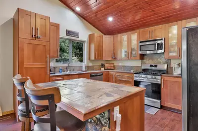 a kitchen with wooden cabinets and a large wooden table at Top Notch Lodge#2056 in Big Bear Lake