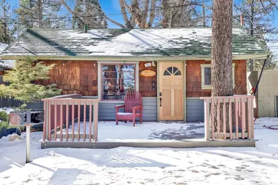 a house with a red chair in the snow at Shore acres lodge #451 in Big Bear Lake